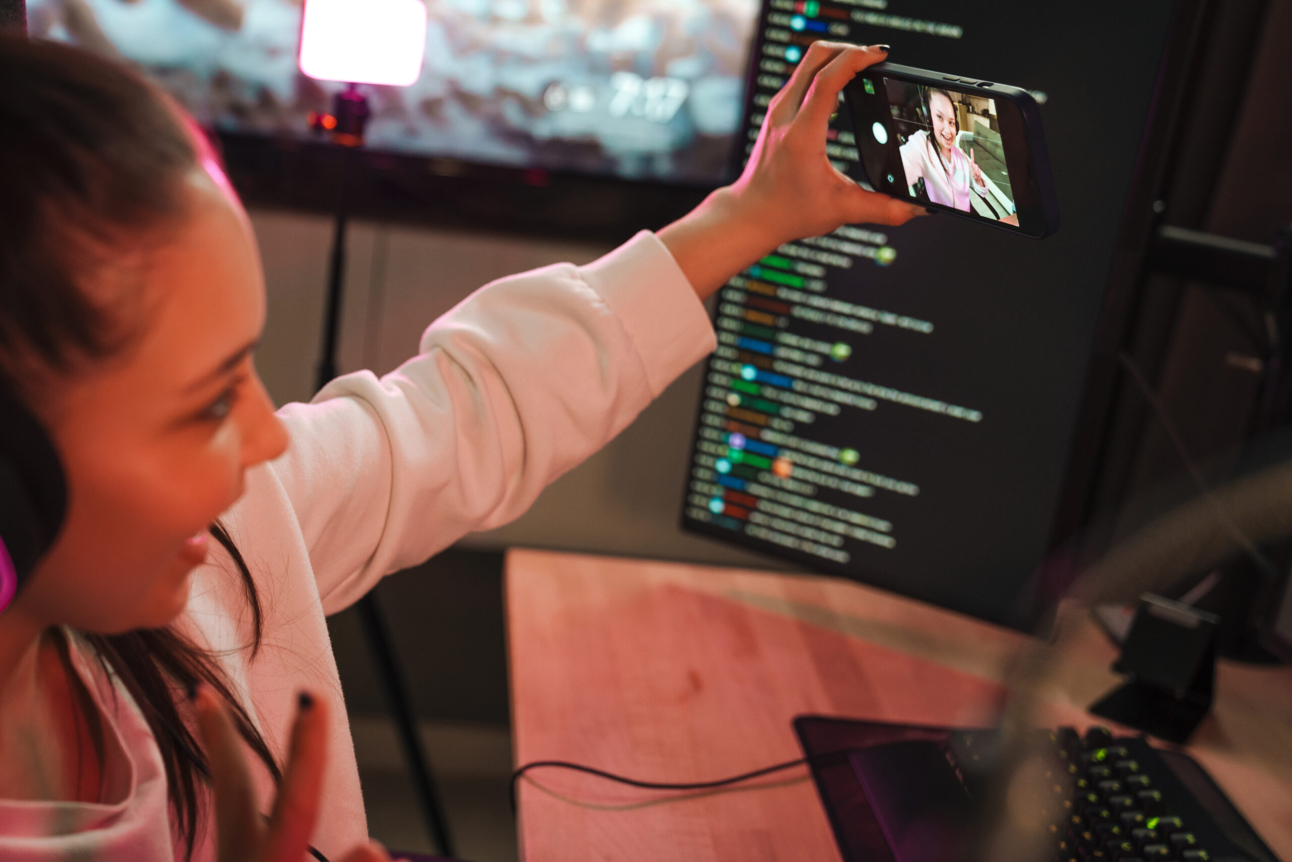 Smiling young woman gamer in headphones